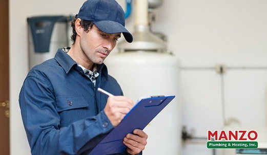 plumber inspecting a water heater
