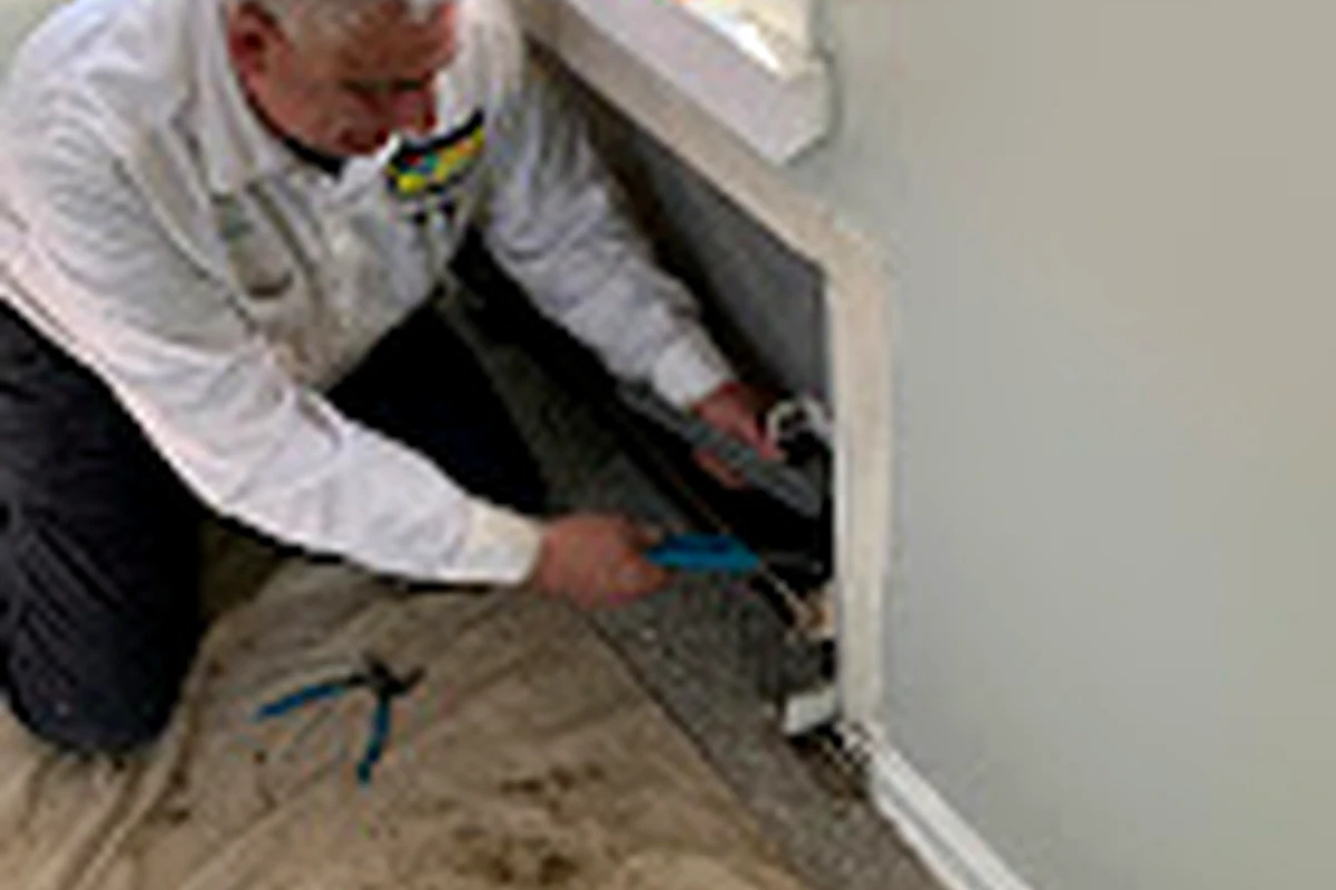 Sal Manzo technician working on baseboard heating inside a Long Island home